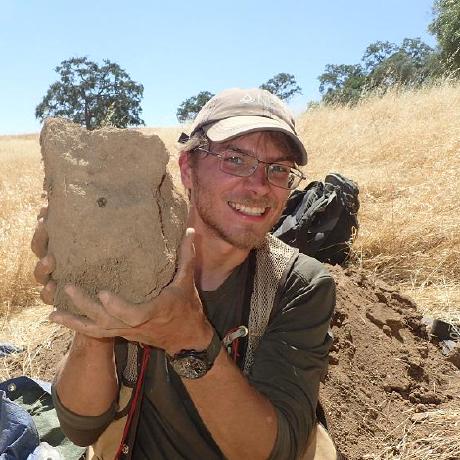 Andrew in the south-central foothills of MLRA 18 (San Joaquin Experimental Range) holding a large clod collected from an Entic Haploxeroll soil for bulk density analysis.